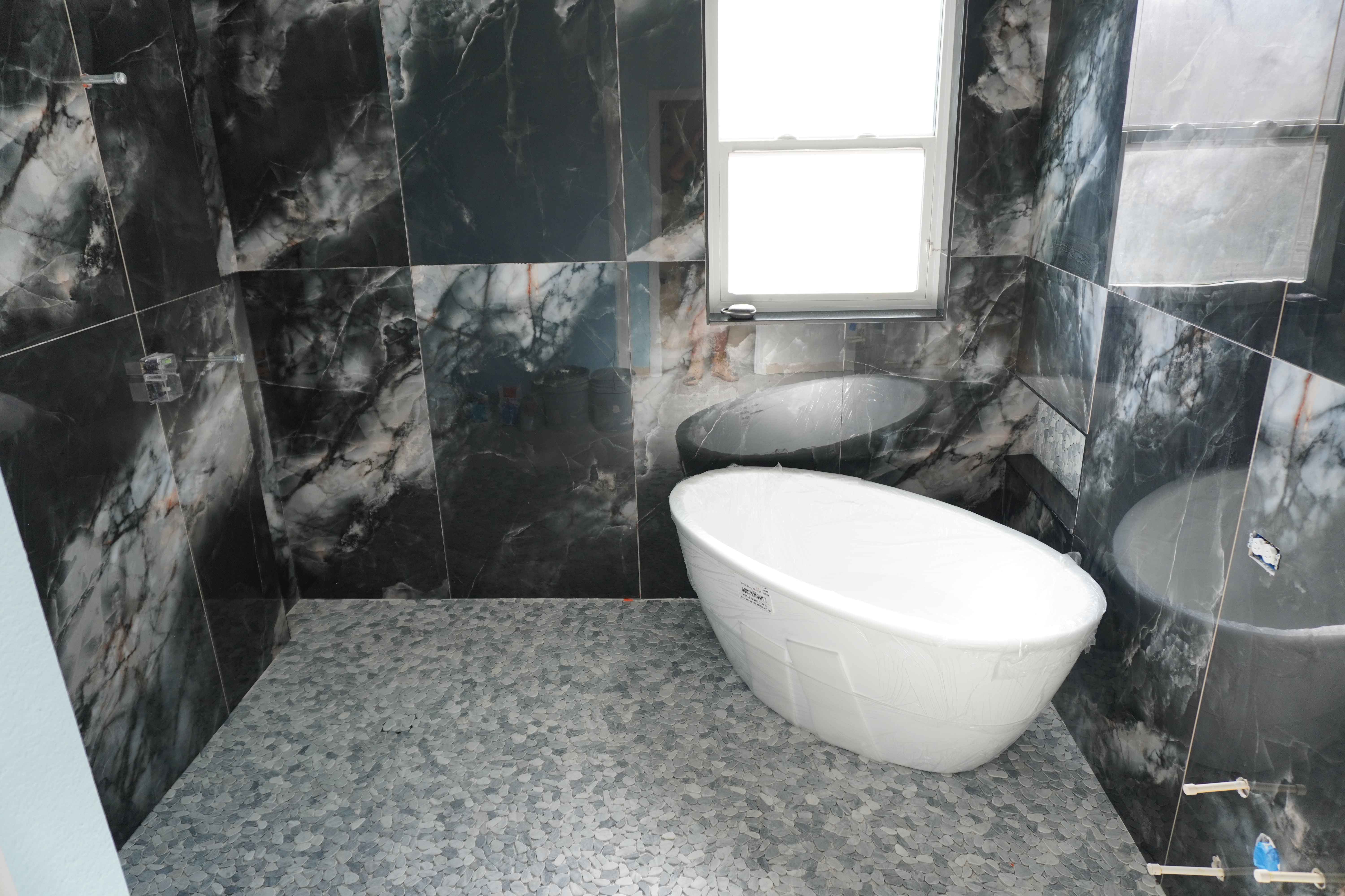Dark marble master bathroom with freestanding tub and walk-in shower