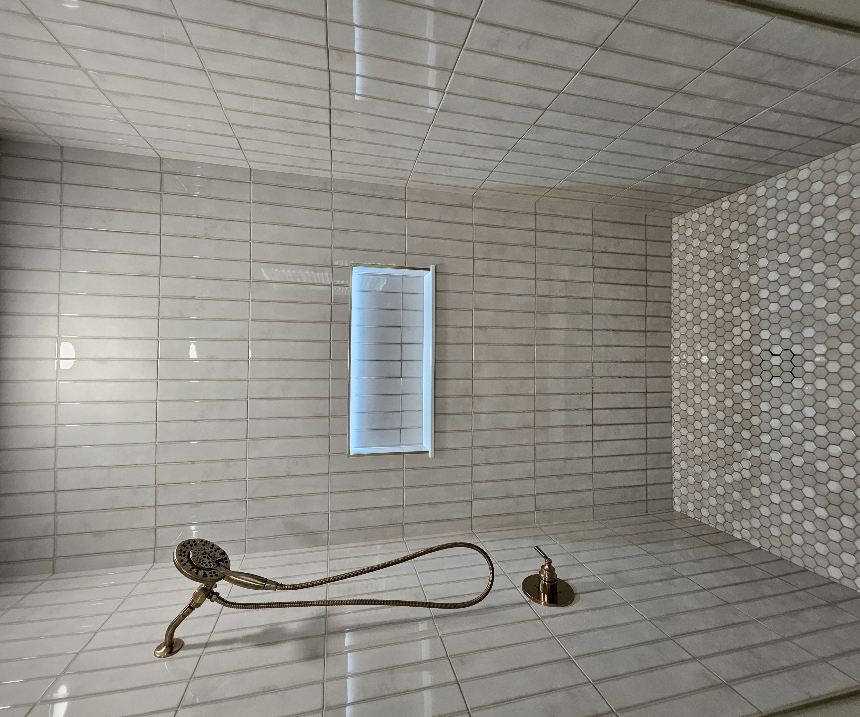 Custom guest shower with tile niche and frameless glass enclosure